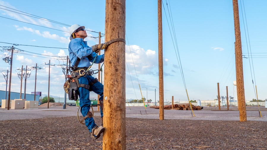 Lineworker climbing an electrical pole