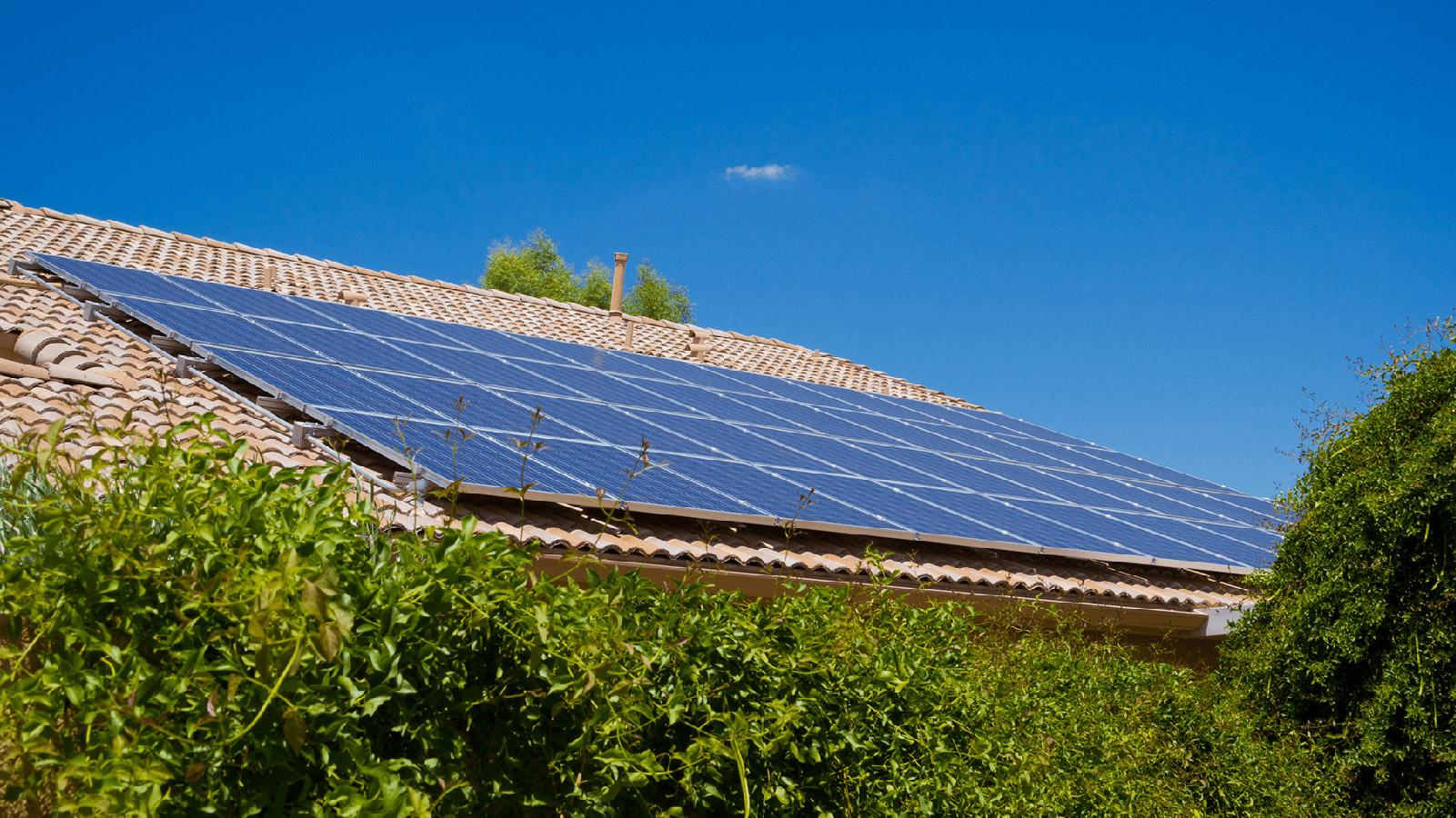 Solar panel on a rooftop against a blue sky.