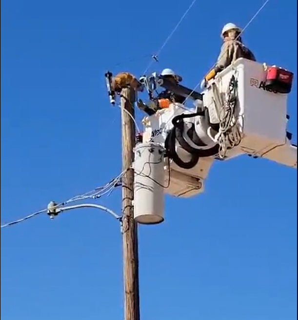 Cat being rescued off a power pole by APS crews in Toltec, Arizona