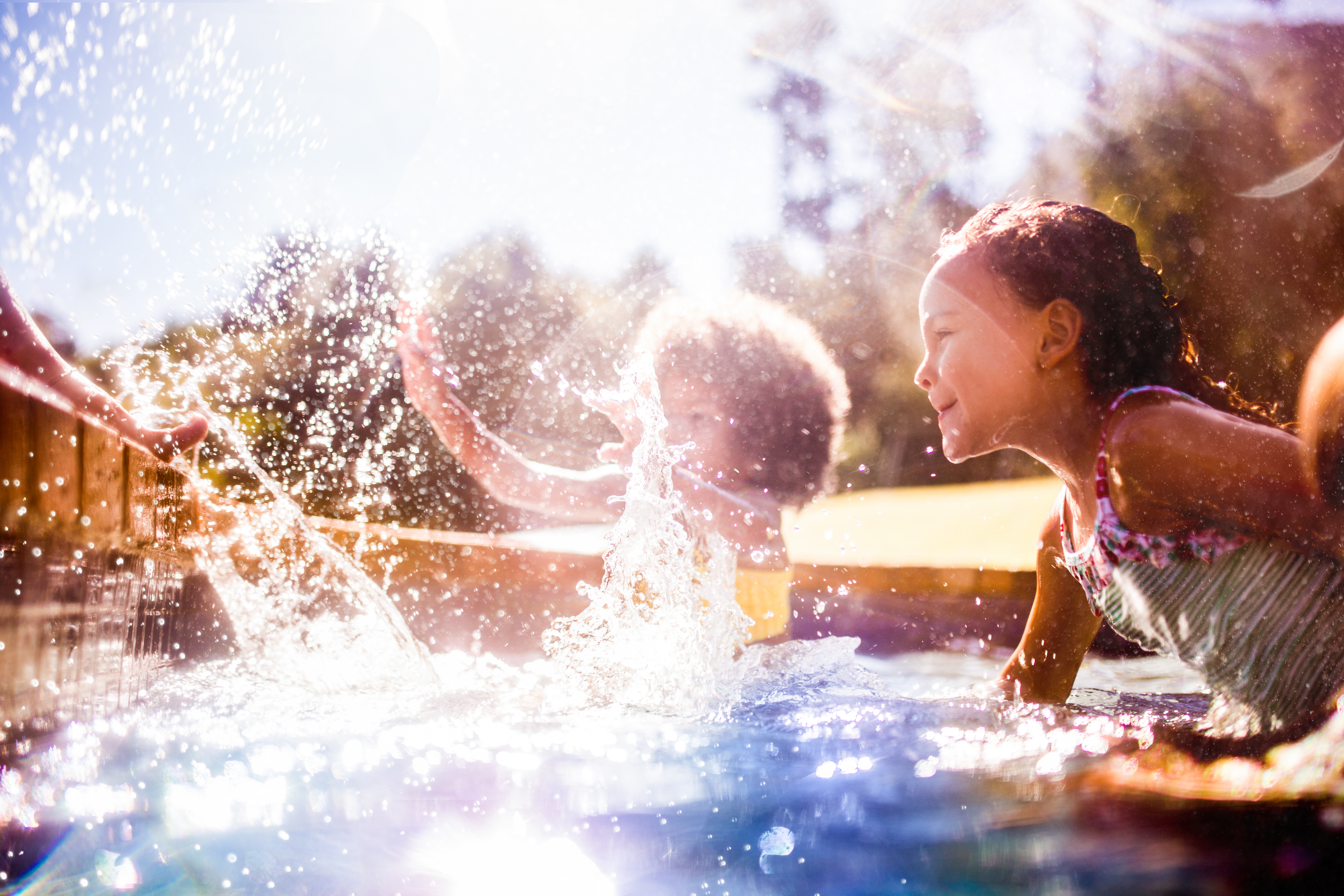 Kids swimming in a sunny pool