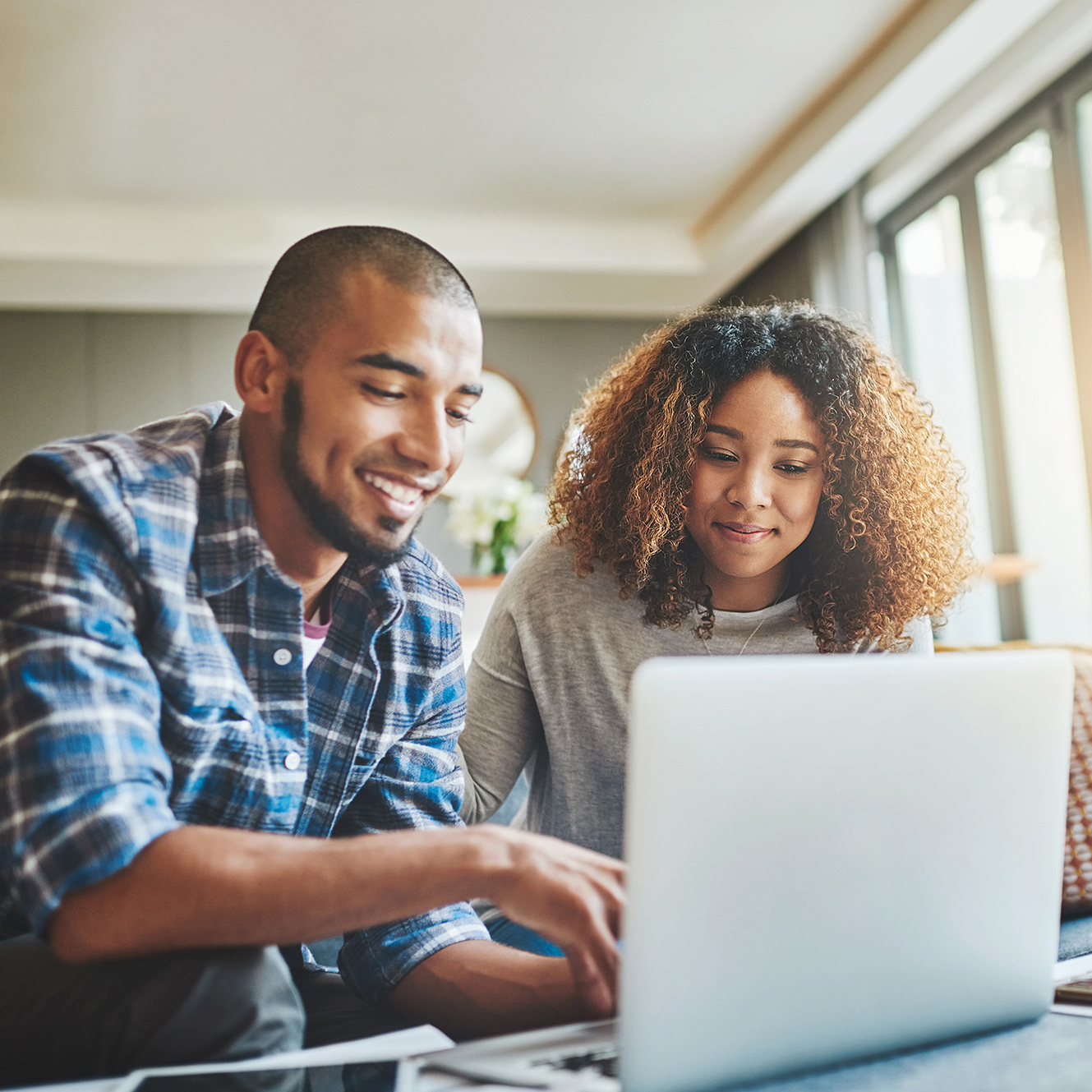 Two individuals choosing the right plan using their laptop.