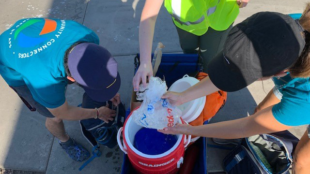 Volunteers filling a cooler with ice